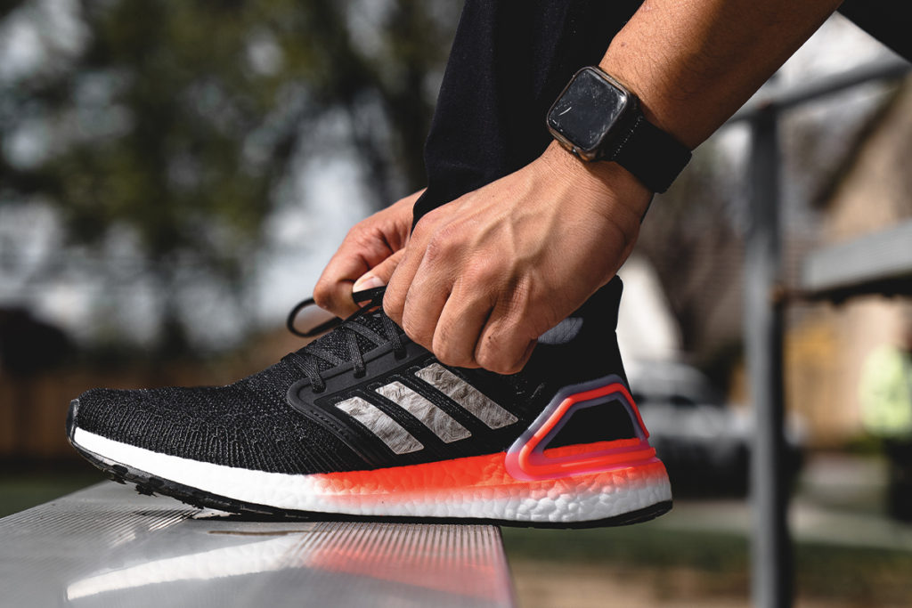 runner lacing an adidas running shoe